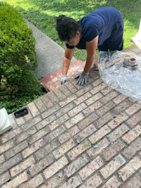 a man is laying brick on a sidewalk