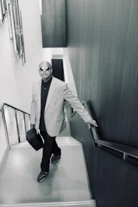a man in a suit walking down stairs