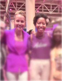 two women posing for a picture at a convention